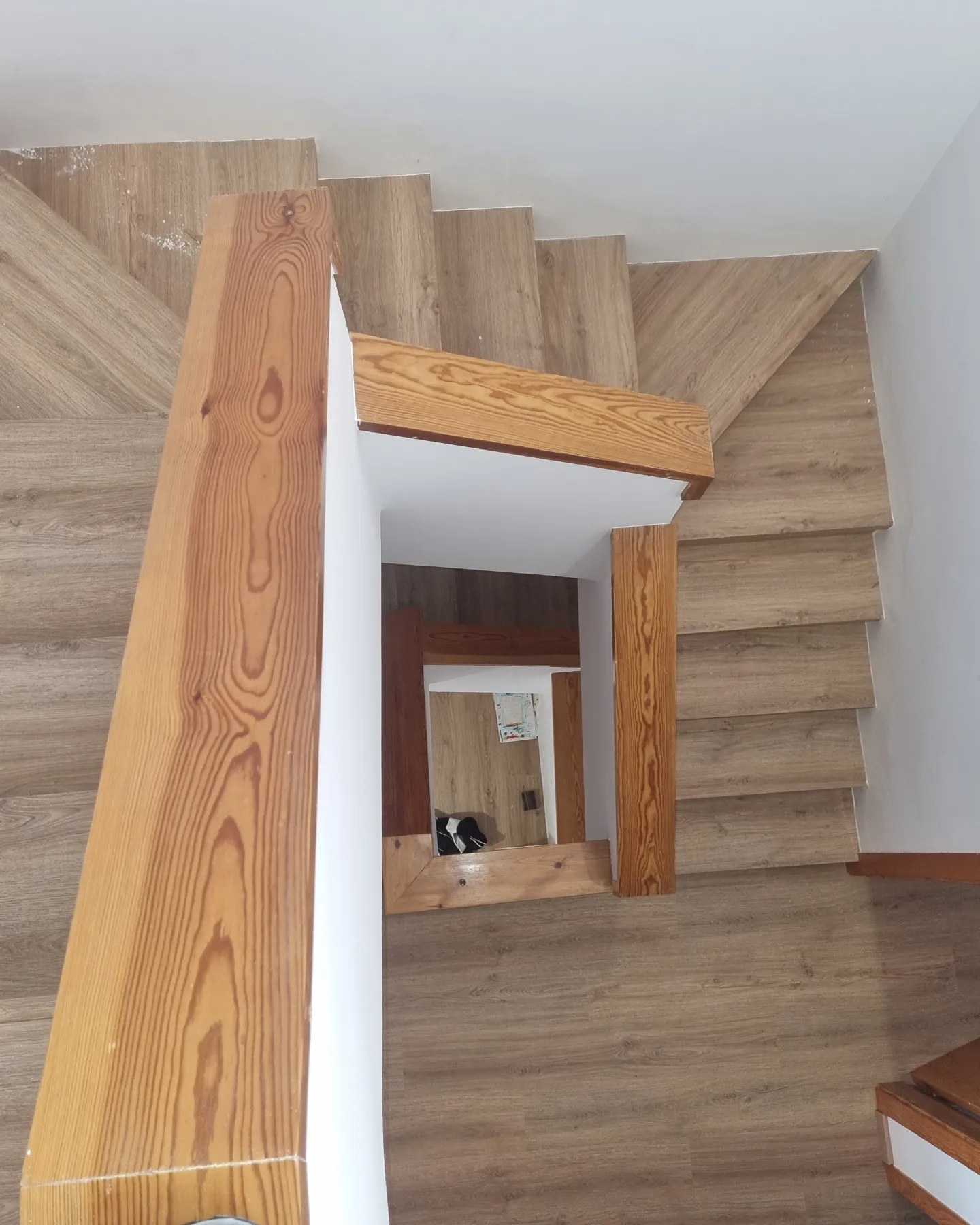 Vista superior de la escalera con peldaños, descansillos y pasamanos